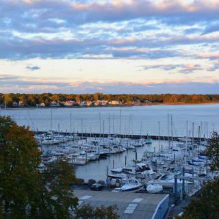 A serene marina filled with boats, set against a picturesque sunset sky.