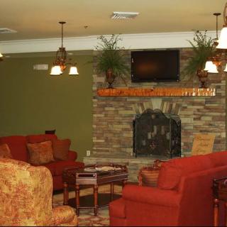 A cozy living room with a stone fireplace and comfortable seating.
