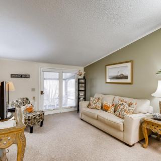 A cozy living room with a beige sofa, patterned chairs, and decorative accents.