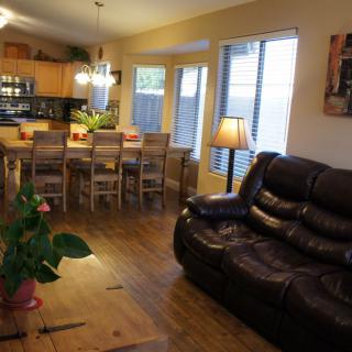 Open-concept living and dining area with a cozy sofa and wooden furniture.
