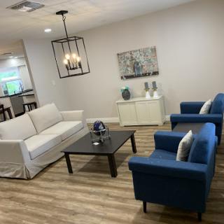 Cozy and modern living room setup with stylish blue chairs and a white sofa.