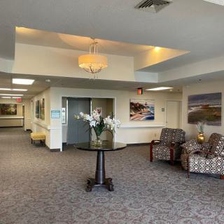 A spacious lobby with seating area, decorative lighting, and artwork on the walls.