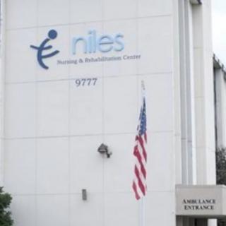 Exterior of a healthcare facility with an American flag and signage.