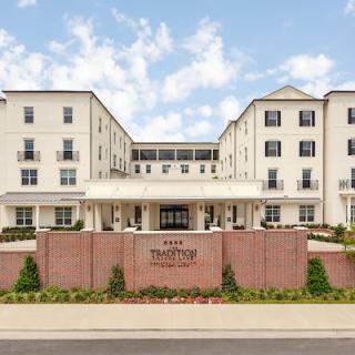 Front view of a multi-story hotel building with a landscaped entrance.