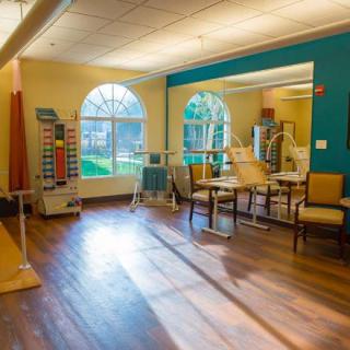 A spacious and well-lit physical therapy room with various exercise equipment.