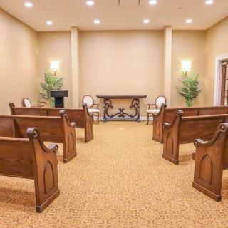A small chapel with wooden pews and ornate decor.