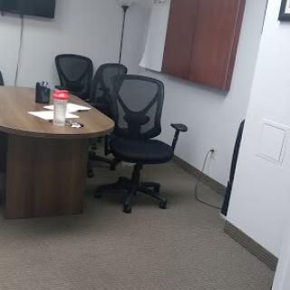 A view of a modern conference room with a round table and ergonomic chairs, ready for a meeting.