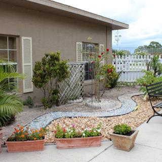 A well-maintained backyard garden with decorative landscaping and potted plants.