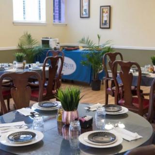 A cozy dining area with elegantly set tables and wooden chairs, exuding a welcoming atmosphere.