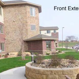 Front exterior view of a residential building with landscaped surroundings.