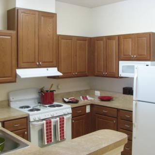 A modern kitchen with wooden cabinets and standard appliances.
