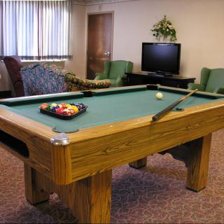 A game room featuring a pool table, television, and comfortable seating.