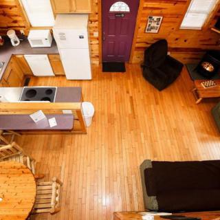 A cozy wooden interior with an open floor plan, featuring a kitchen and living area.