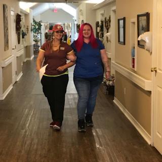 Two friends joyfully walking down a hallway.