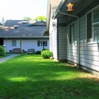 A view of a residential area with well-kept lawns and a pathway leading between houses.