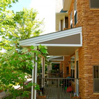 A building with brick exterior and balconies featuring awnings.