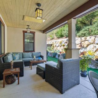 A cozy outdoor porch with comfortable seating and decorative plants, perfect for relaxation.