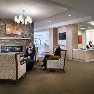 A cozy lobby area with comfortable seating and a fireplace, where people are relaxing and conversing.