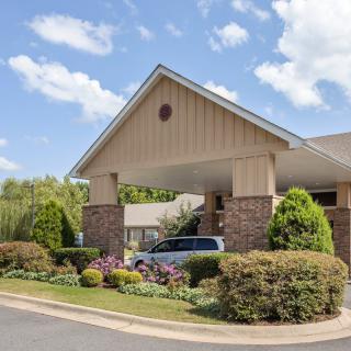 A building entrance with well-maintained landscaping and blue skies in the background.