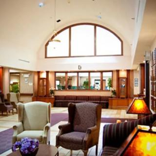 A spacious and well-lit hotel lobby with comfortable seating and a reception desk.