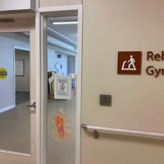 Entrance to a rehabilitation gym, featuring accessibility signage.