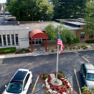 Aerial view of a building with an American flag and landscaped area in the foreground.