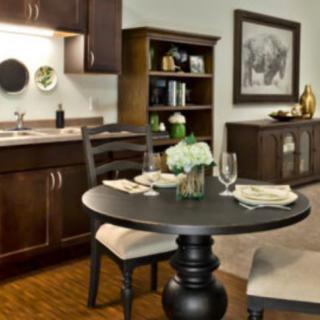 A cozy dining area with a round table, chairs, and stylish decor in a kitchen setting.