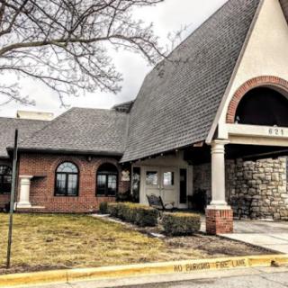 A charming, rustic building with a steep roof and stone entrance on an overcast day.