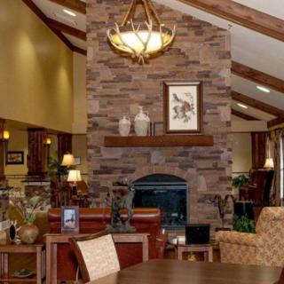 A cozy living room with a stone fireplace and warm lighting.