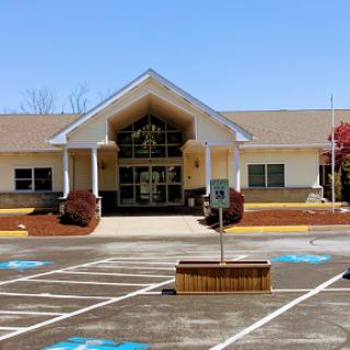 A modern building featuring a welcoming entrance and well-maintained parking area.
