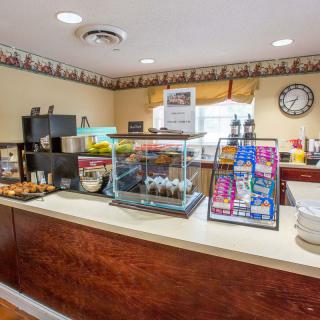 A hotel breakfast area with a variety of self-service food and drinks.