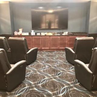 A cozy home theater setup with comfortable seating facing a large screen.