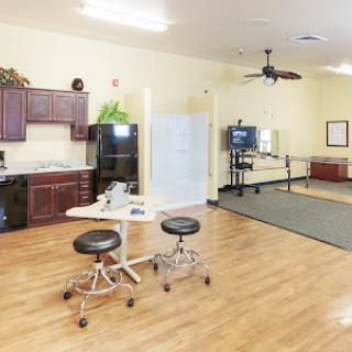 A spacious and well-equipped rehabilitation center featuring a kitchenette and therapy area.