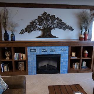 Cozy living room with a blue-tiled fireplace and decorative wall art.