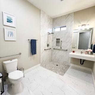 A modern bathroom featuring a spacious shower, sleek fixtures, and elegant tile work.