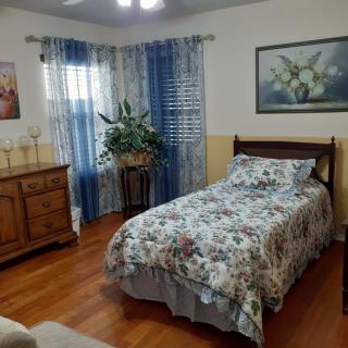 A cozy bedroom with floral bedding and wooden furniture.