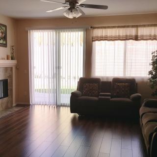 A cozy living room with a fireplace and large windows letting in natural light.
