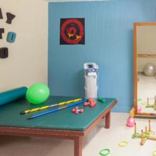 A therapy room equipped with various exercise tools and a mirror for physical rehabilitation.