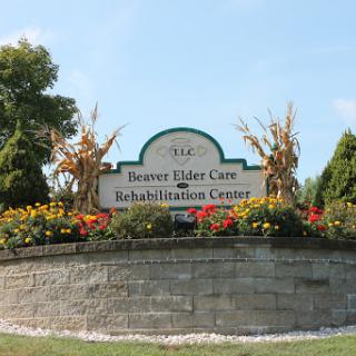 Entrance sign of a senior care and rehabilitation facility surrounded by flowers.