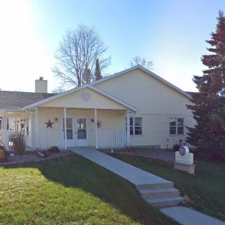 A suburban house with a front yard and pathway leading to the entrance.