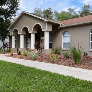 A residential house with a landscaped garden and arched entrance.