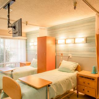 A modern hospital room designed for patient comfort, featuring two beds and natural light.