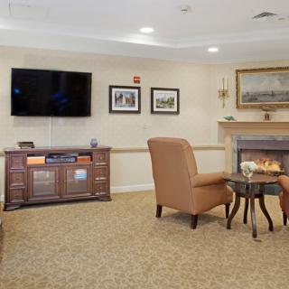 A cozy living room with a television, comfortable chairs, and a fireplace.