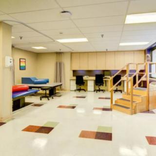 A rehabilitation room with exercise equipment and therapy stations.
