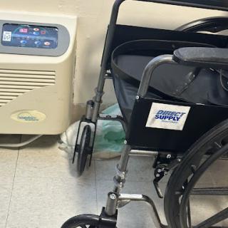 A wheelchair positioned next to a medical air conditioning unit.