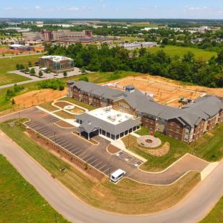 Aerial view of a suburban building complex with surrounding greenery.