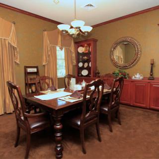A traditional dining room with a wooden table, chairs, and elegant decor.