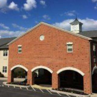 A brick building with a clock tower under a blue sky.