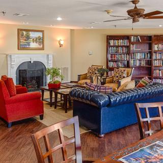 A cozy living room with a fireplace, bookshelves, and comfortable seating.