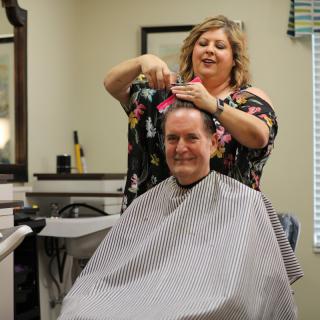 A hair stylist giving a haircut to a customer in a salon.